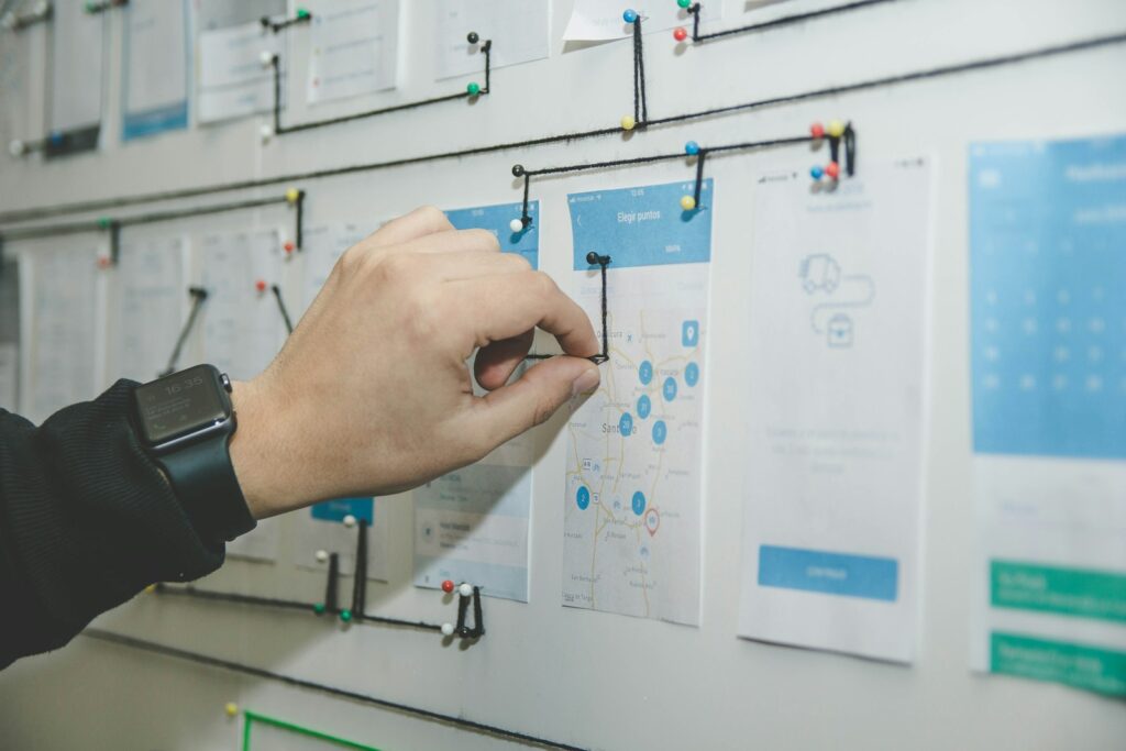 Designer mapping user journeys and screens on a wall during the design process