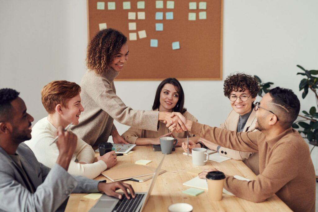 A team reviewing a project together on a laptop in a bright office