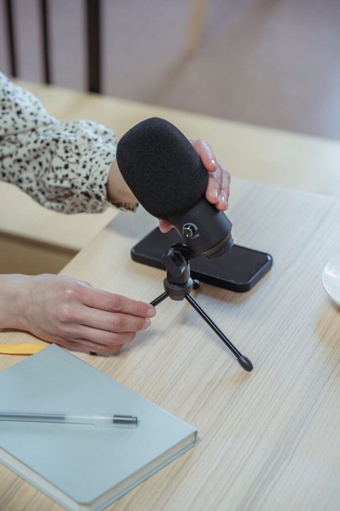 Setting up a podcast microphone on a desk for a recording session